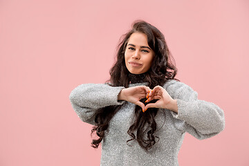 Image showing Portrait of attractive cute girl with bright makeup with kiss and love sign isolated over pink background