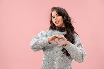 Image showing Portrait of attractive cute girl with bright makeup with kiss and love sign isolated over pink background