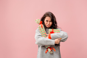 Image showing Woman with big beautiful smile holding colorful gift boxes.