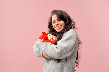 Image showing Woman with big beautiful smile holding colorful gift box.