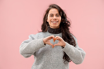 Image showing Portrait of attractive cute girl with bright makeup with kiss and love sign isolated over pink background