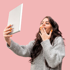 Image showing Portrait of a confident casual girl looking at laptop isolated over pink background