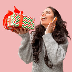 Image showing Woman with big beautiful smile holding colorful gift box.