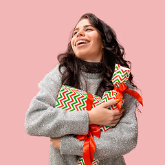 Image showing Woman with big beautiful smile holding colorful gift boxes.