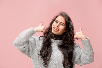 Image showing The happy business woman standing and smiling against pink background.