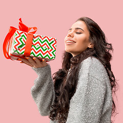 Image showing Woman with big beautiful smile holding colorful gift box.