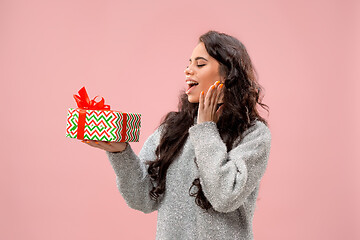 Image showing Woman with big beautiful smile holding colorful gift box.