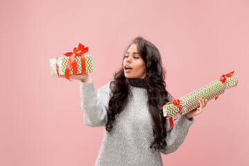 Image showing Woman with big beautiful smile holding colorful gift boxes.