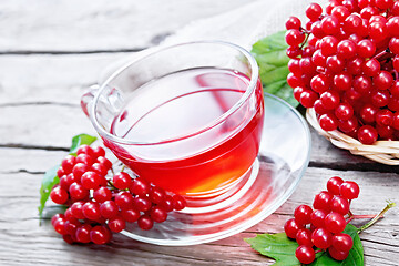 Image showing Tea from viburnum in cup on wooden board