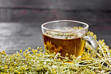 Image showing Tea of gray wormwood in glass cup on dark board