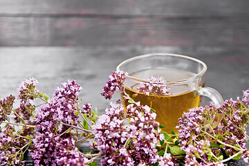 Image showing Tea of oregano in glass cup on board