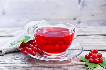 Image showing Tea from viburnum in cup with berries on gray wooden board