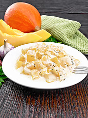 Image showing Pumpkin with sour cream sauce in plate on wooden table