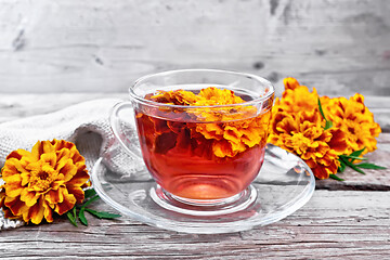 Image showing Tea herbal of marigolds in glass cup on board