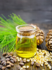 Image showing Oil cedar in glass jar on wooden board