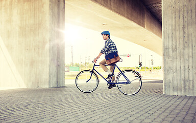 Image showing young hipster man with bag riding fixed gear bike