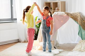 Image showing happy girls playing near kids tent at home