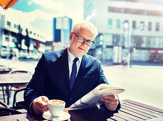 Image showing senior businessman with newspaper drinking coffee