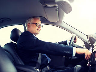 Image showing happy senior businessman starting car and driving