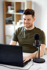 Image showing man with laptop and microphone at home office