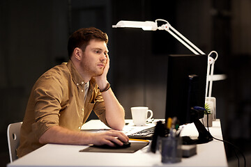 Image showing tired or bored man working late at night office