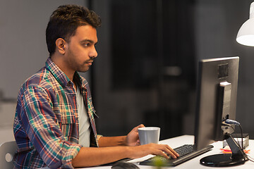 Image showing creative man with computer working at night office