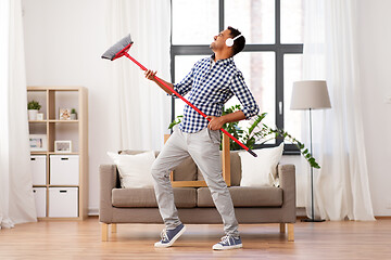 Image showing man with broom cleaning and having fun at home