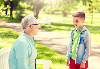 Image showing grandfather and grandson talking at summer park