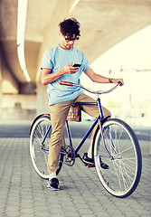 Image showing man with smartphone and earphones on bicycle