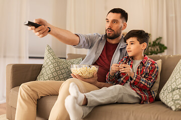Image showing father and son with popcorn watching tv at home