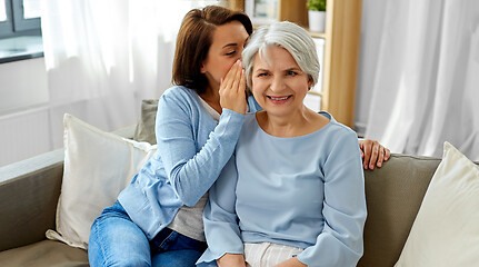 Image showing adult daughter whispering to senior mother at home