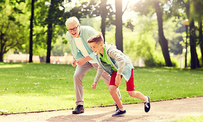 Image showing grandfather and grandson racing at summer park