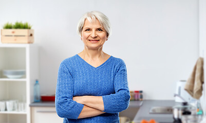 Image showing smiling senior woman in blue sweater at kitchen