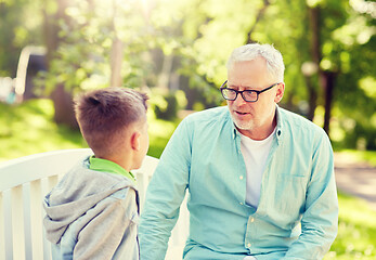 Image showing grandfather and grandson talking at summer park