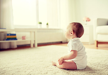 Image showing happy baby boy or girl sitting on floor at home