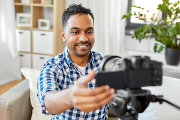 Image showing indian male video blogger adjusting camera at home