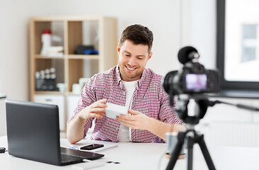 Image showing male blogger with camera videoblogging at home