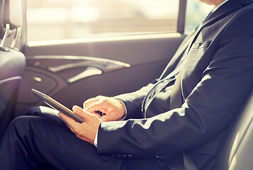 Image showing senior businessman with tablet pc driving in car