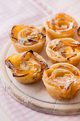 Image showing Delicious apple puff pastry in rose shape on wooden board