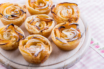 Image showing Delicious apple puff pastry in rose shape on wooden board