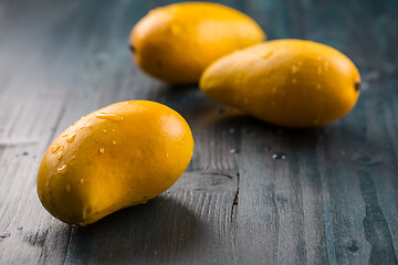 Image showing Fresh honey mango fruits on wooden background