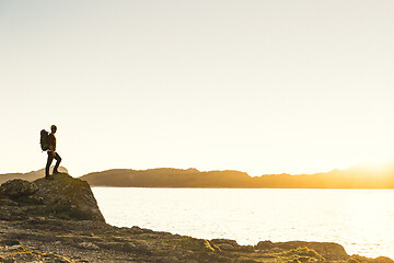 Image showing Man exploring the coast line at sunset