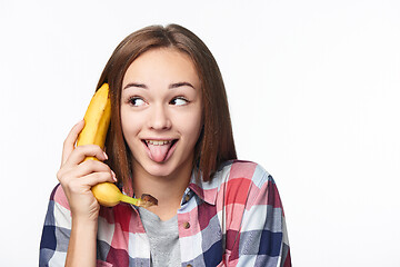 Image showing Teen girl holding banana like a phone, looking to side