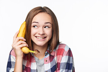 Image showing Happy emotional teen girl holding banana like a phone