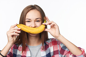 Image showing Teen girl holding banana like a smile in front of her lips