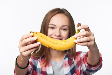 Image showing Teen girl outstretching giving you a banana