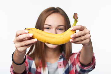 Image showing Teen girl outstretching giving you a banana, forming a creative smile in front of her face