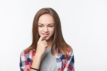 Image showing Sly teen girl thinking biting her finger looking to side