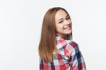 Image showing Smiling relaxed teen girl looking at camera over shoulder