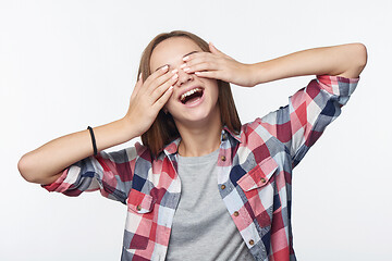 Image showing Emotional joyful teen girl covering her eyes with palms